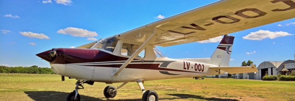 Cessna 150 · LV-OOJ. Ala alta y librea borgoña; mañana clara antes de rodar.
